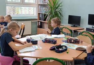 Dzieci pracują podczas zajęć przy stoliku