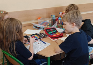 Dzieci współpracują ze sobą w grupie przy stoliku
