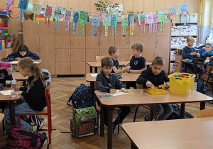 Dzieci pracują na zajęciach świetlicowych przy stolikach