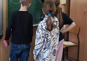 Dzieci wspólnie tworzą rysunek na tablicy