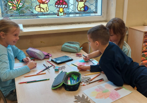 Uczniowie siedzą przy stoliku