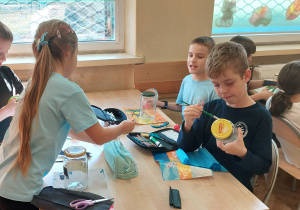 Uczniowie pracują przy stoliku