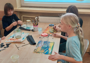 Dzieci siedzą w ławce