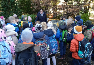 Uczniowie stoją przed pomnikiem