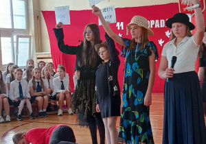 Uczennice pokazują kartki z imionami i nazwiskami wybitnych Polaków