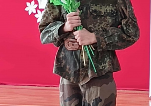 Uczeń przebrany z Józefa Piłsudskiego z kwiatami