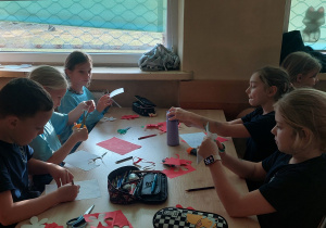 Uczniowie siedzą przy stoliku