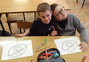 Uczniowie siedzą w ławce