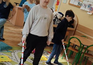 Dzieci pokonują tor przeszkód dla osoby niewidomej