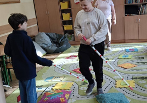 Dzieci wykonują ćwiczenie praktyczne na dywanie