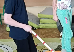 Dzieci wykonują ćwiczenie w parze na dywanie