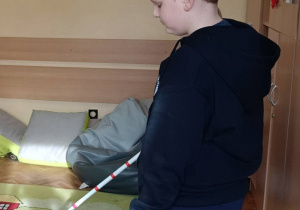 Uczeń pokonuje tor z laską dla osób niewidomych