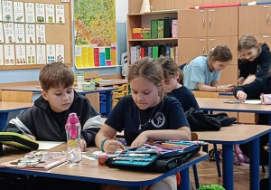 Uczniowie współpracują w ławkach wykonując ćwiczenie ze zmysłem wzroku