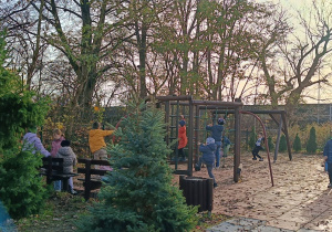 Dzieci wykonują ćwiczenie praktyczne na placu zabaw w grupie