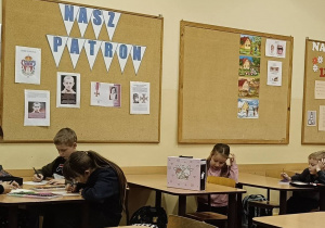 Uczniowie w ławkach wykonują portret Orląt walczących