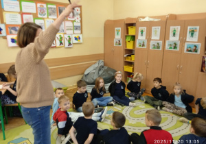 Uczniowie siedzą na dywanie