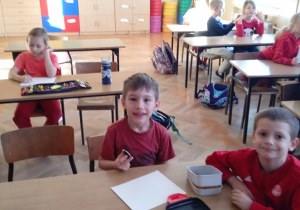 Uczniowie siedzą w ławkach