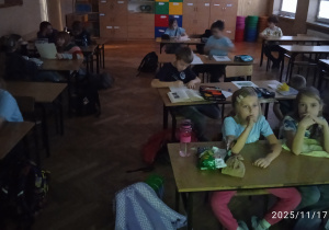 Uczniowie siedzą w ławkach