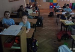 Uczniowie siedzą w ławkach
