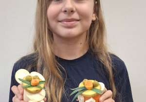 Uczennica trzyma swoje prace