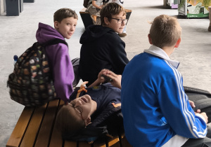 Uczniowie siedzą na ławce