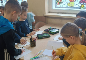 Dzieci odrysowują swoją dłoń a następnie wpisują sobie komplementy