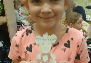 Dziewczynka trzyma narysowanego misia