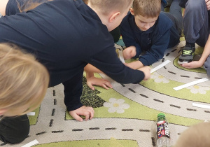 Dzieci siedzą na dywanie