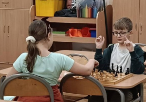 Dzieci podczas gry w szachy okazując sobie serdeczność