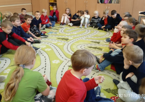 Dzieci siedzą na dywanie