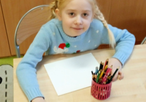 Uczennica siedzi w ławce