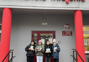 Uczniowie stoją przed wejściem do przedszkola