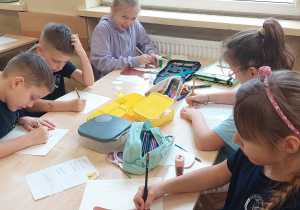 Uczniowie pracują przy stoliku