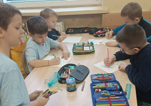 Dzieci wspólnie wykonują ćwiczenie plastyczne dotyczące choinki