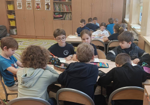Dzieci współpracują w grupie podczas zajęć o choince