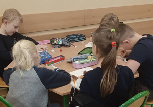 Uczniowie pracują w ławce wykonując ćwiczenie na wyobraźnię