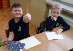 Uczniowie siedzą w ławce