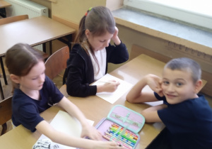 Uczniowie pracują przy stoliku