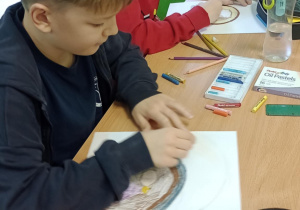 Uczniowie siedzą w ławce