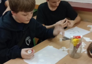 Uczniowie siedzą w ławce