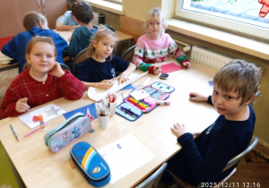 Uczniowie tworzą prace plastyczne siedząc w ławce