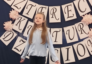 Uczennica stoi na scenie i recytuje