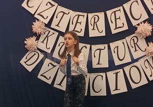 Uczennica stoi na scenie i recytuje