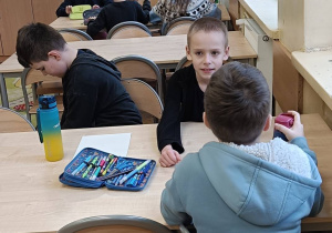 Dzieci pracują w grupach wykonując ćwiczenie o osobach niepełnosprawnych mapa myśli