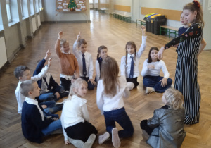 Uczniowie siedzą w kole