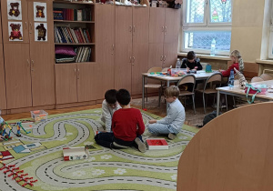 Dzieci wspólnie wymyślają pomysły na dywanie w świetlicy na zabawę