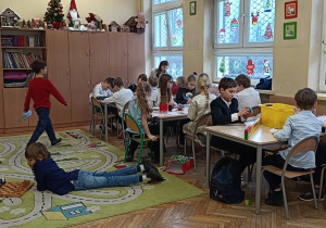 Dzieci wykonują ćwiczenie praktyczne przy stolikach