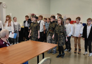 Uczniowie stoją w sali