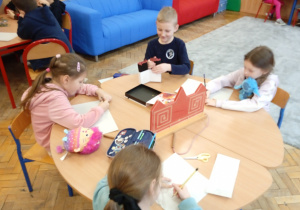 Uczniowie pracują przy stolikach