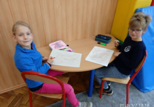 Uczniowie siedzą przy stoliku